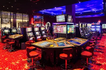 Un croupier professionnel en smoking accueille les joueurs à une table de roulette, symbolisant l'ambiance authentique du casino en direct sur KWANZA.