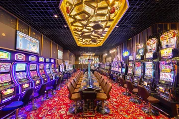 Un homme célèbre un moment gagnant sur son ordinateur tandis que des symboles de jeu flottent autour de lui, capturant l'énergie des jeux KWANZA.